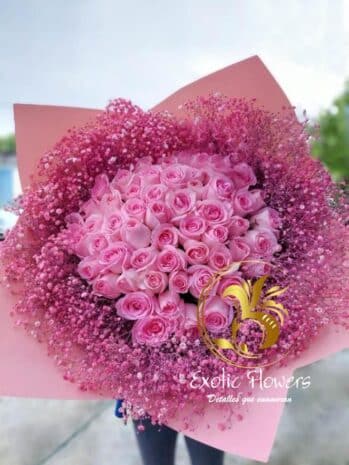 xquisita combinación de rosas envueltas en papel decorativo y un moño delicado.