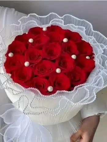 Manual elegante de rosas rojas envuelto en organza con perlas y el mensaje ¡Feliz Día Mamá! floristería exotic flowers domicilio en bucaramanga y área metropolitana.