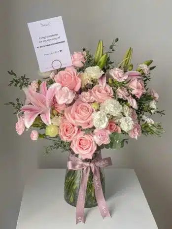Jarrón con rosas rosadas, claveles blancos y lirios, ideal para cumpleaños y el Día de la Madre.
