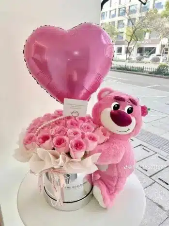 Arreglo floral encantador con rosas frescas, peluche y globo, ideal para regalar en momentos especiales.
