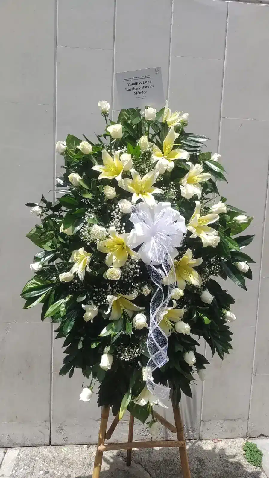 Arreglo Floral para Condolencias en Lirios y Follajes Verdes