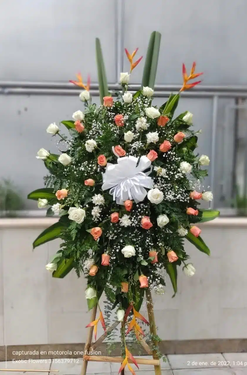 Arreglo floral pedestal fúnebre con rosas de Exotic Flowers Bucaramanga, ideal para ceremonias de despedida.