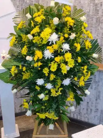 Ramo pedestal fúnebre con flores amarillas de Exotic Flowers Bucaramanga, perfecto para ceremonias conmemorativas.
